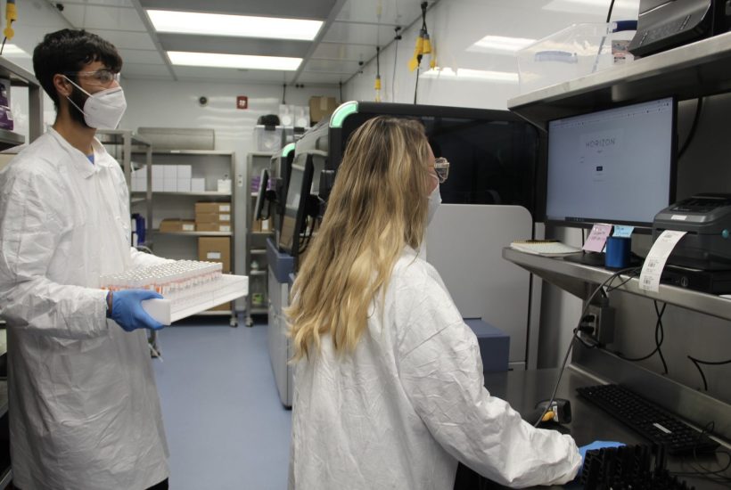 Clinical laboratory scientists working mobile BSL-2+ clinical laboratory Two people working in a mobile clinical laboratory