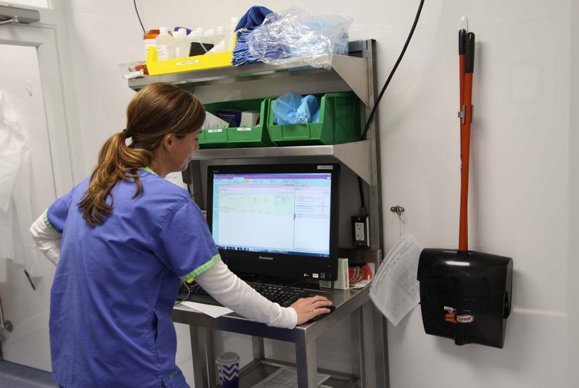 duke-raleigh-mobile-usp-797-800-pharmacy-2 Person working at a computer in a mobile pharmacy