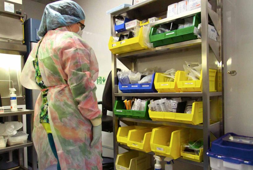 duke-raleigh-mobile-usp-797-800-pharmacy-3 Person looking at items on a shelving unit inside a mobile pharmacy
