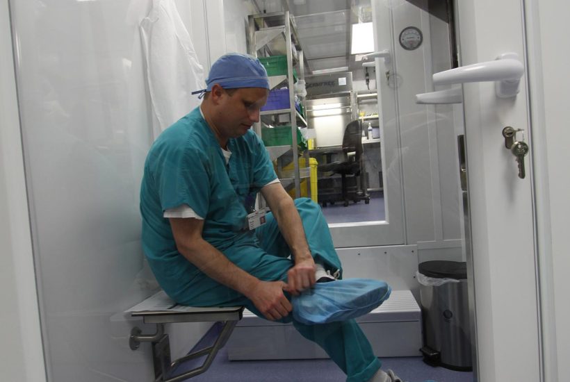 Mobile 797 800 cleanroom gowning room Man in the cleanroom gowning room preparing to enter the Sterile Compounding Pharmacy
